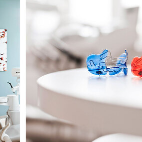 Zwei bunte Zahnspangen liegen auf einem Tisch in einer modernen Zahnarztpraxis.